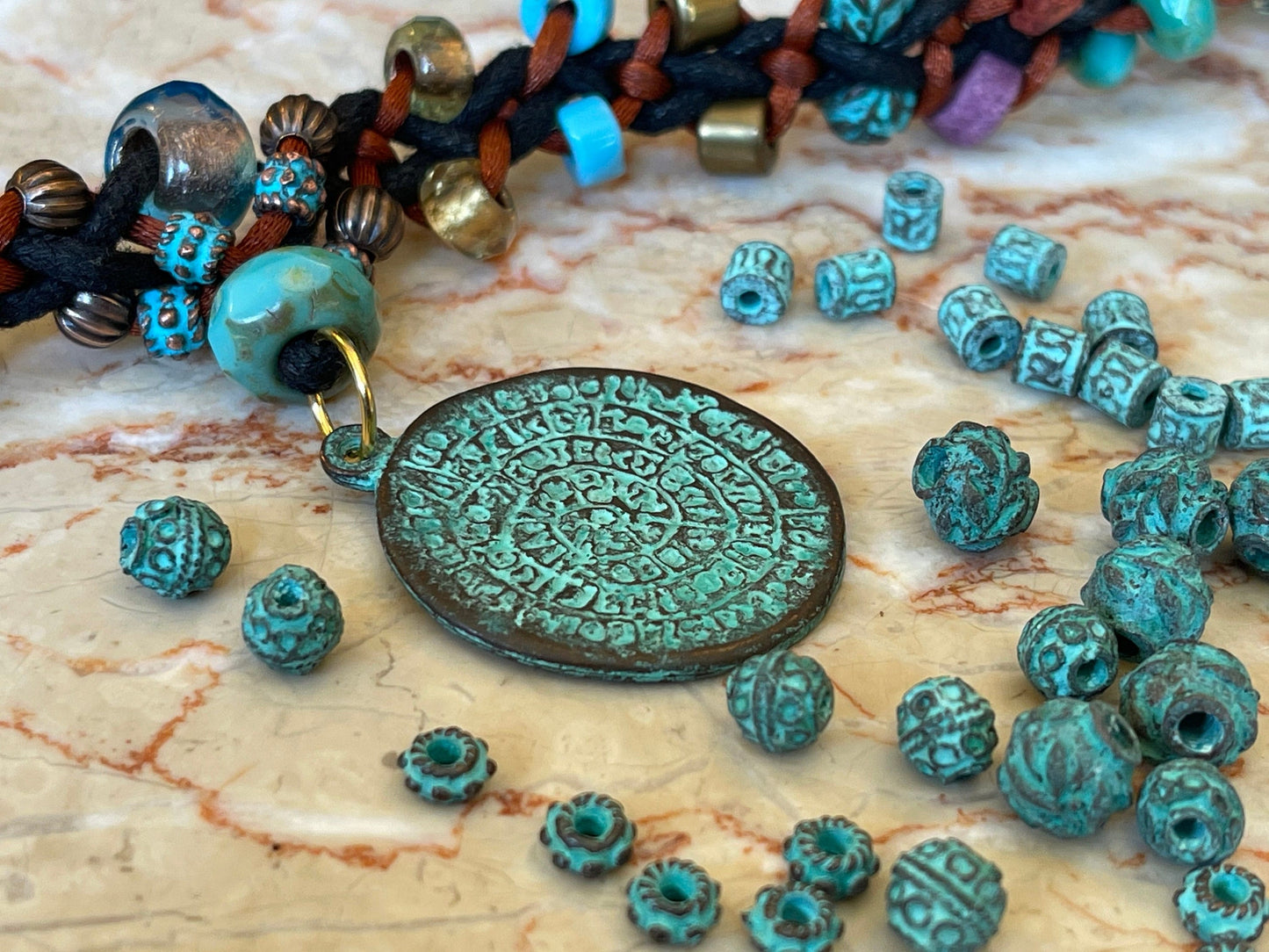 Phaistos Disk pendant charm – cast bronze with a green patina – made in Mykonos Greece – detailed replica of Archaeological artifact