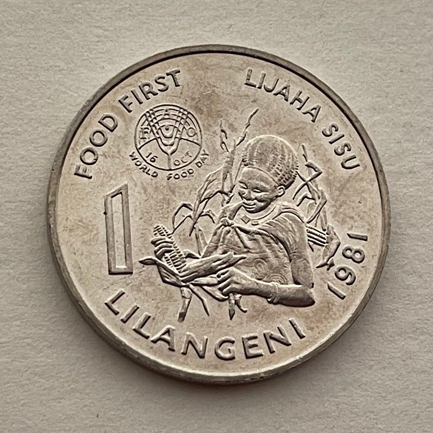 Woman with Beehive Sicolo Hairdo, Husking Corn & King Sobhuza 1 Lilangeni Swaziland Authentic Coin Money for Jewelry (1981) (Eswatini) Maize